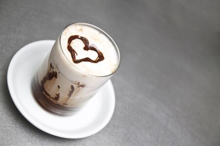 Cup of milk with a heart made with liquid chocolate.