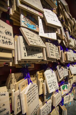 Tokyo, Japan - March 26, 2016: A wall of wooden wishing plaques. One front of ema has space for writing one wish and another front usually have decorated illustration sのeditorial素材