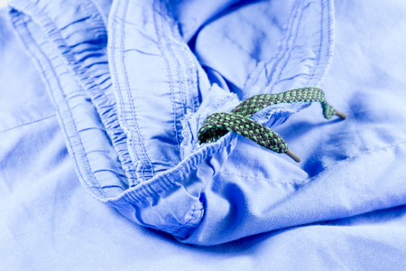 blue fabric texture background and green shoelace