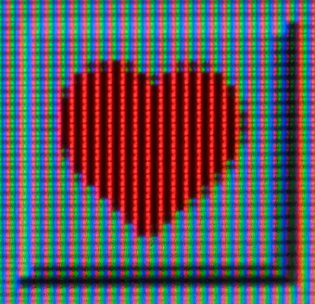 An extreme macro of an LCD screen, showing a red heart.  の写真素材