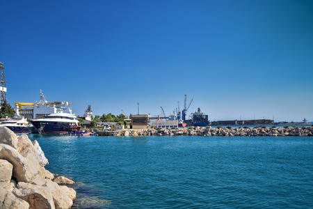 sea yachts under repair in a dry dock, on a slipway, against the background of port buildings,...