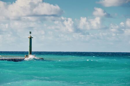coastline of the Atlantic Ocean, an old lantern on a stone pier indicating the passage for small shipsの写真素材