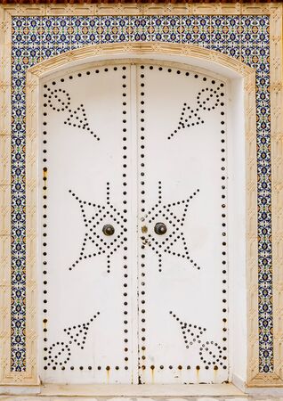 Entrance double door in the wall of an old building in a traditional North African styleの写真素材