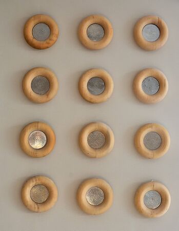 twelve decorative electric lamps with a wooden frame in the wall, arranged in a repeating pattern