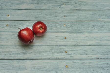 two red apples on an isolated background in the form of old boards