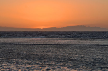sunrise over the sea against the backdrop of the mountainsの写真素材