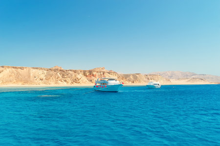 yacht in the sea, against a background of a deserted shore, waves, blue skyの写真素材