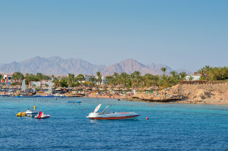 speedboat off the coast, sea, beach, vacationers, buildings, against the backdrop of mountains and...