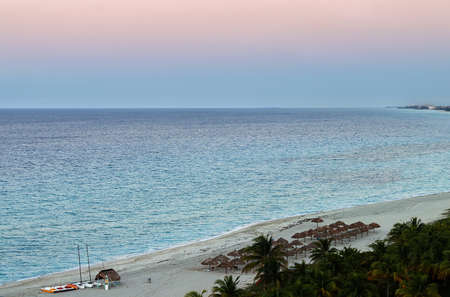 a bird's eye view of the Atlantic coast in the evening, at sunset, with beach umbrellas on the beach, yachts, pedal boats, and palm trees.の写真素材