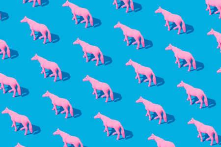 Collage of pink rubber horses isolated on blue background.