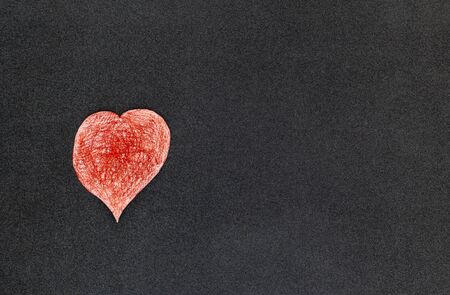 A paper-cut heart painted on a black backgroundの写真素材
