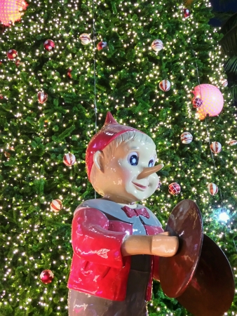 A big doll in front of christmas treeの素材