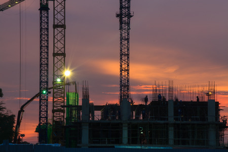 Building cranes silhouette against evening sky の写真素材