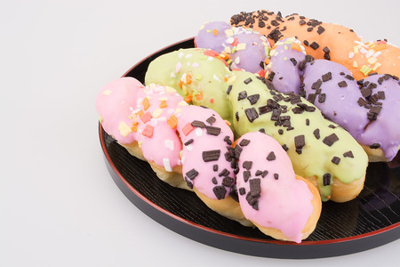 Twisted donuts in a plate on white background.