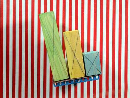 Colorful wood blocks of different size placed on a board that tgradually tilts, one by one they...