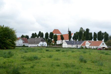 Spang, Denmark - August 30, 2013: View to the village Ulkebol, with church and old houses.
