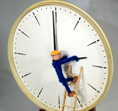 Clockman adjusting a clock to or back from Daylight Saving Time (DST)の写真素材