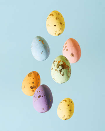 minimal creative concept of colorful pastel easter falling eggs on blue backgroun.の写真素材