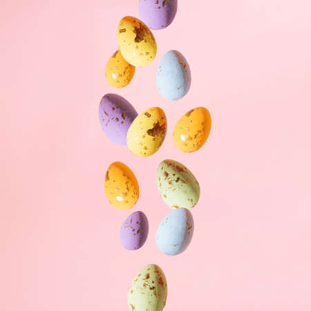 minimal creative concept of colorful easter falling eggs on pastel pink backgroun.の写真素材