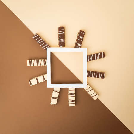flat lay composition of white and brown chocolate  wafers with copy space frame on two colors background. minimal creative concept.の写真素材