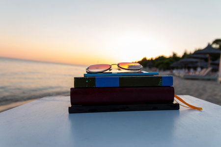 Books on the beach beside sea at sunset. School conceptの写真素材