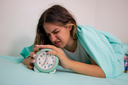 Teen girl hates waking up early in the morning.Beautiful girl feeling bad, she has  menstrual pain and  suffering from headache, emotions and stressの写真素材