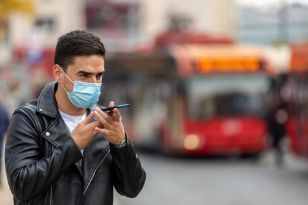 Portrait of man in a medical surgical mask in the summer city. Coronavirus, illness, infection, quarantine.の写真素材