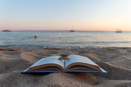 Books on the beach beside sea at sunset. School concept