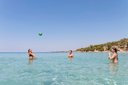 Happy teenagers  playing volleyball in water at the beach.Traveling, vacation and funの写真素材