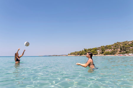 Happy teenagers  playing volleyball in water at the beach.Traveling, vacation and funの写真素材