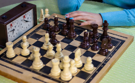 Hand of girl makeing a movement with a chess pieceの写真素材