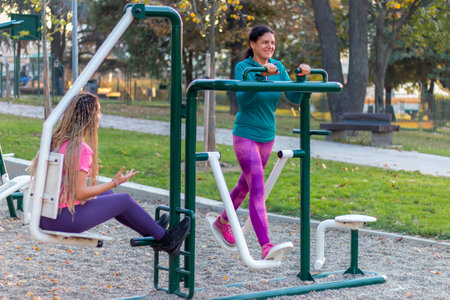 Mother and daughter are working out at the outside gym and having healthy and active lifestyle Fun exercises and strength health.の写真素材