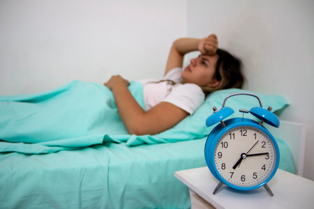 Teen girl hates waking up early in the morning.Beautiful girl feeling bad, she has  menstrual pain and  suffering from headache, emotions and stressの写真素材