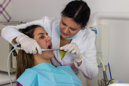 Teenager girl having her teeth checked by doctorの写真素材