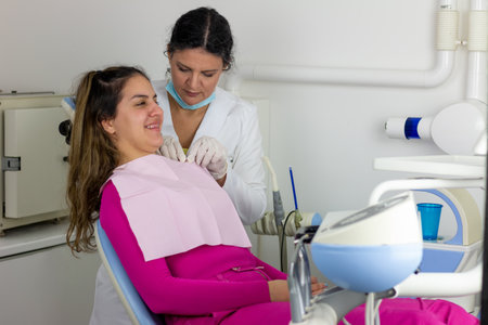 Dentist doctor puts dental napkin on patient. Preparing the patient for a dental examinationの写真素材