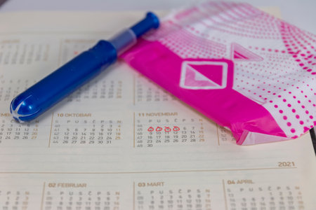 Reminder PMS and Period in calendar with red pen. Closeup.