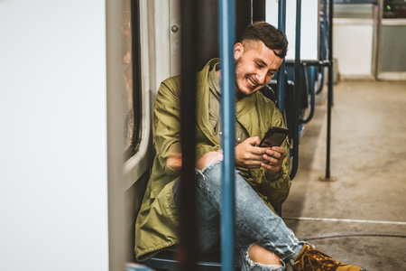 People, lifestyle, travel and public transport. Attractive man looking at the phone while sitting in public bus.の写真素材