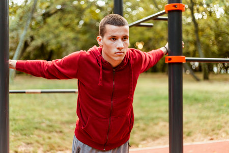 Sport man stretching at the park autumn, doing exercises.Handsome man do stretching exercises at...