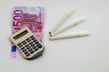 Close up view of euros, calculator and cigarettes. Dont spend money on unhealthy life.の写真素材