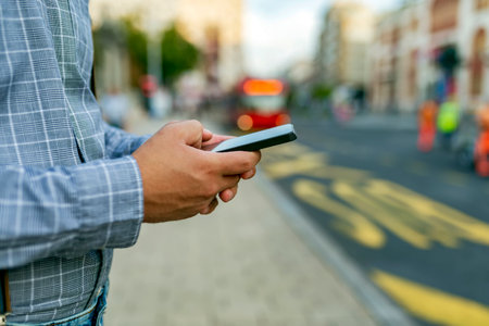 Close up View of Smart Phone in Male Hand in the City Streetsの写真素材