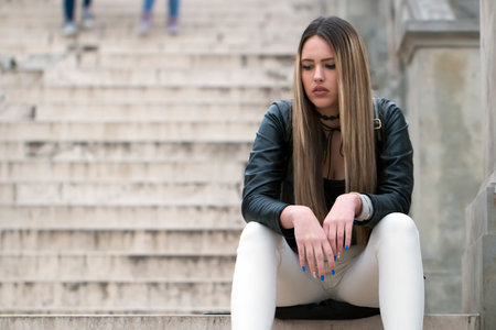 Portrait stressed sad young woman standing outdoors. City life style stress.の写真素材