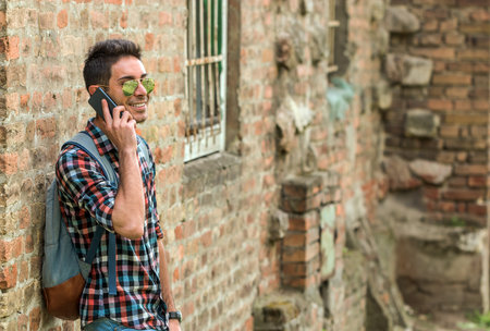 Handsome hipster talking on the phone. Close up portrait of cheerful mature man using mobile phone and laughing.の写真素材