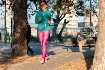 Beautiful active mature woman jogging or taking a walk in the park. Sport healthy lifestyle, concept