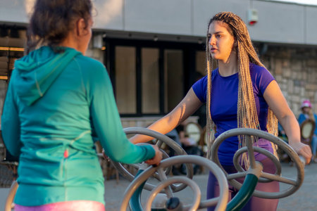 Smiling Women Have Fun Doing Exercises in Public Open Air Gym Equipment to Stay fit. The concept of...