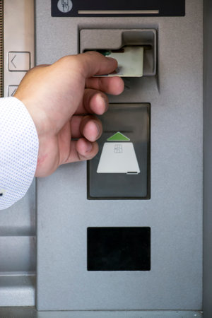 Closeup of man inserting credit card in ATM machineの写真素材
