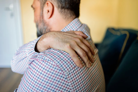 Unhappy Man Suffering From Neck Or Shoulder Pain At Home. Shoulder Pain Caused By Not Taking Care Of Health. People, Healthcare And Problem Concept.の写真素材
