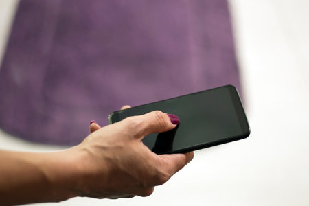 Woman with Red Nails Using a Smart Phone in the Streetの写真素材