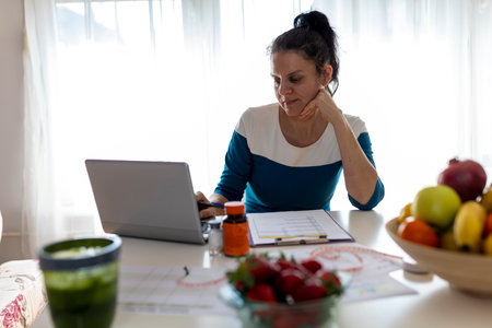 Woman nutritionist working from home and making plans for her clientsの写真素材
