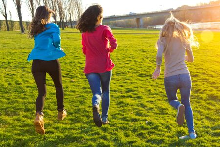 Three girls running in the park after classの写真素材