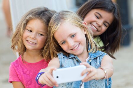 Portrait of group of childrens taking a selfie in the park.の写真素材